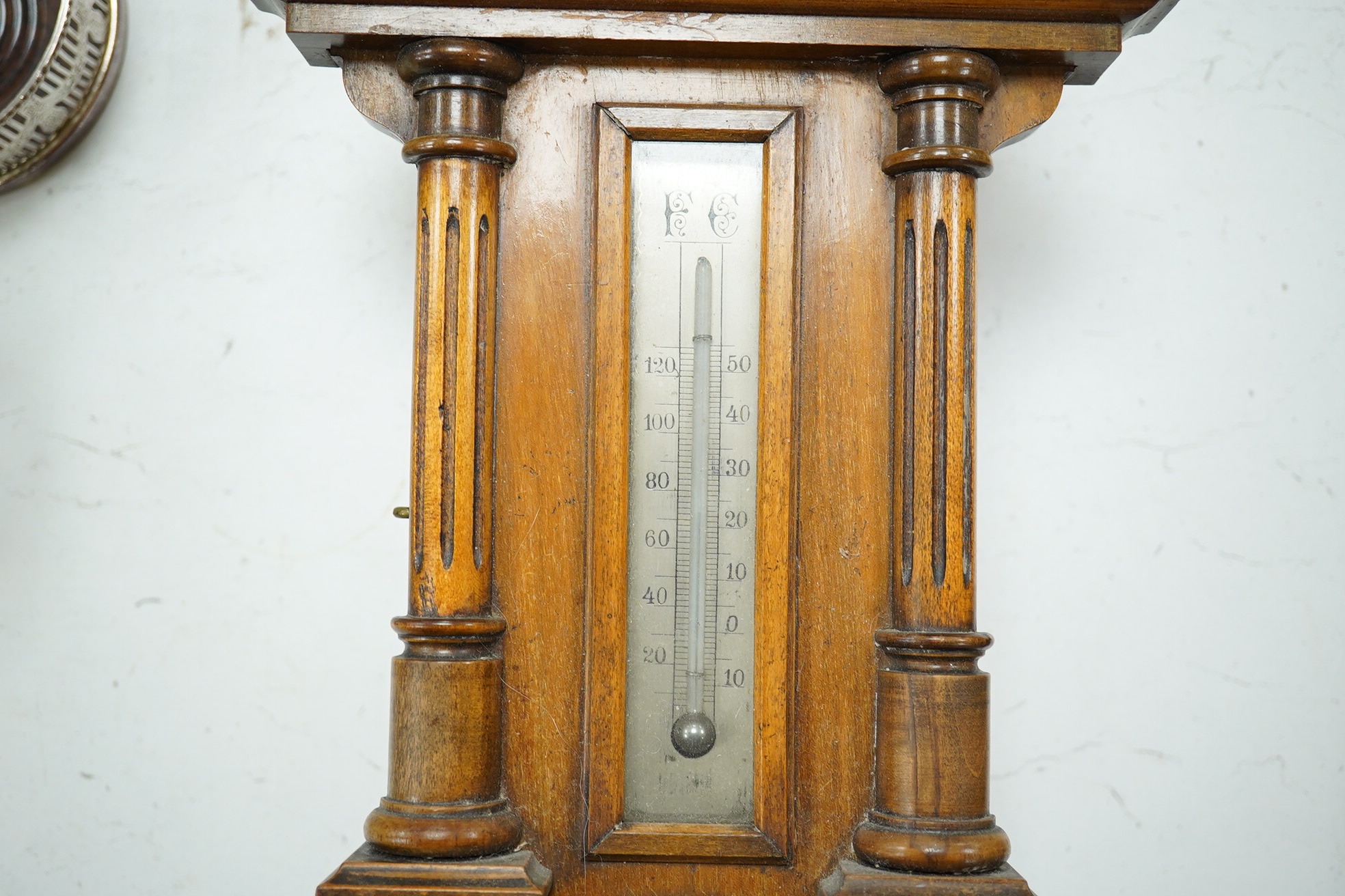 A late 19th century walnut wall clock, barometer and thermometer combination, striking on a coiled gong, 65cm high. Condition - fair, crack to the case and finial missing to the bottom